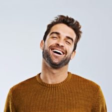 Single Post 2 studio shot of a happy and handsome man laughing against a gray background e1701832909525